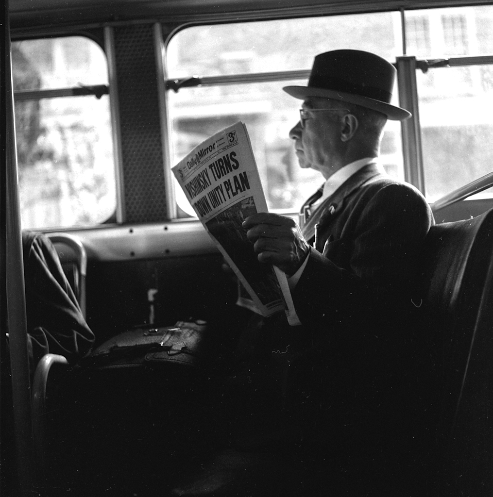 Man reading on bus, 1949