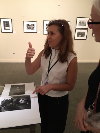 A docent at the exhibition in Arles gives a thumbs up Feintein's photograph "Draftees on the troopship home", which she said was a favorite for many viewers.  